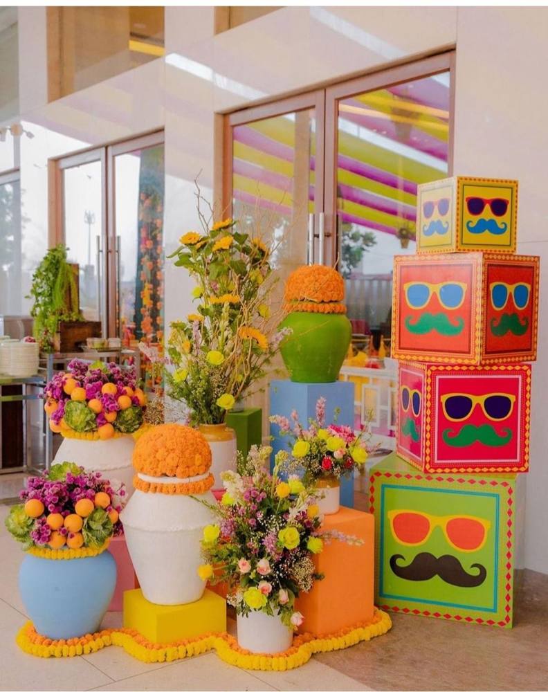 Colourful mehendi corner with painted boxes and flower pots