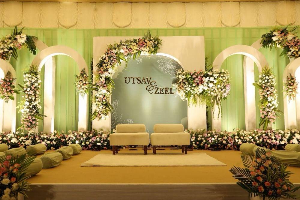 Reception stage with white arches and pastel flowers